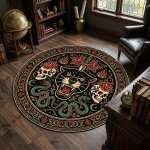 May include: A round area rug featuring a black panther head at the center, surrounded by two skulls, red roses, green snakes, and flaming eyes. The design includes a decorative border with intricate patterns in shades of red, gold, and teal.