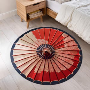 May include: A round red and white Japanese-style umbrella rug with a blue border and intricate patterns. The rug is made of soft, durable materials and is perfect for adding a touch of Asian-inspired style to any room.