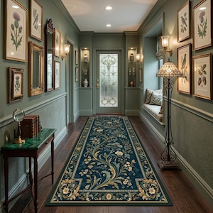 May include: A long, rectangular runner rug featuring a deep teal background with intricate, flowing floral patterns in cream, gold, and sage green. The design includes symmetrical scrolling vines and blossoms, framed by a decorative border on a dark floor.