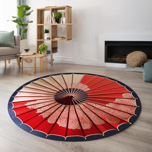 May include: A round red and white area rug with a blue border. The rug features a design of a Japanese umbrella with a swirling pattern.