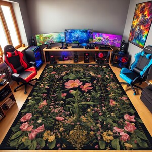 Pu&ograve; includere: Un tappeto floreale nero e oro con rose rosa e foglie verdi. Il tappeto si trova in una sala giochi con una scrivania per computer, sedie da gioco e monitor.