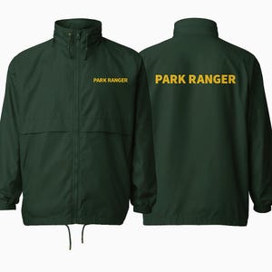 May include: A dark green jacket with the text "PARK RANGER" in gold lettering on the front and back. The jacket has a full zipper, a stand-up collar, and a drawstring at the hem. The jacket is made of a lightweight material.