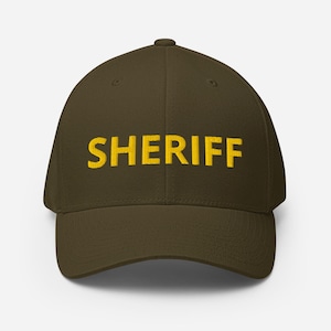 Peut inclure: Une casquette de baseball vert foncé avec le mot "SHERIFF" brodé en jaune.