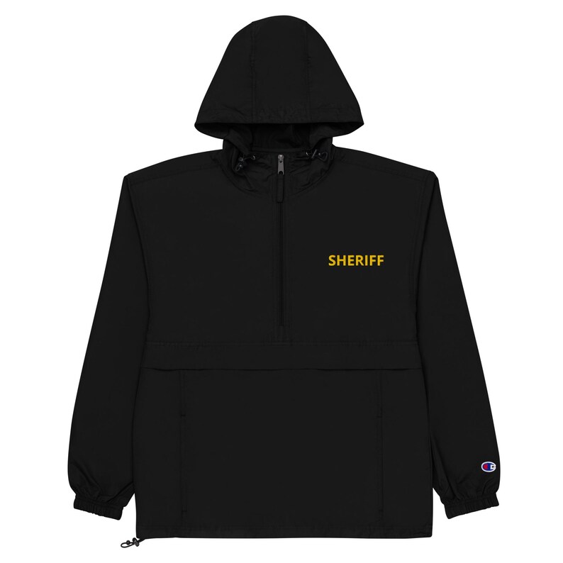 May include: Black hooded anorak jacket with a zipper closure and a gold embroidered "SHERIFF" text on the front.