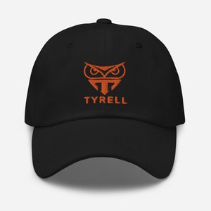 May include: Black baseball cap with an orange embroidered owl logo and the word "TYRELL" below it.