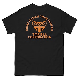 May include: Black t-shirt with an orange graphic featuring an owl and the text "MORE HUMAN THAN HUMAN" in an arch, with "TYRELL CORPORATION" below. The shirt is made of a soft, comfortable material.