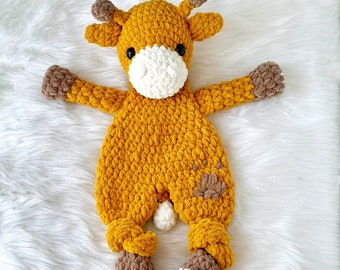 May include: A crocheted stuffed giraffe toy with a yellow body, brown ears and legs, and a white face. The giraffe has black eyes and a white nose.