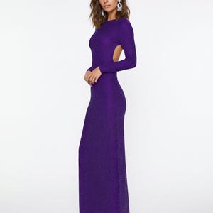 May include: A long, form-fitting, purple dress with long sleeves and an open back. The dress has a textured appearance and a floor-length hemline. The model is wearing silver earrings.