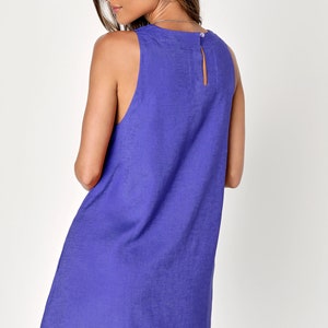 K&ouml;nnte beinhalten: Ein &auml;rmelloses, knielanges Kleid in Periwinkle-Blau. Das Kleid hat einen runden Ausschnitt mit einem kleinen Schl&uuml;sselloch am R&uuml;cken und eine leichte A-Linien-Form. Der Stoff scheint ein strukturiertes Leinen oder &auml;hnliches Material zu sein.