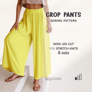 May include: Vibrant yellow crop pants with a wide leg cut, suitable for stretch knits. The image features the text "CROP PANTS SEWING PATTERN" and "8 SIZES". The pants are worn with brown sandals.