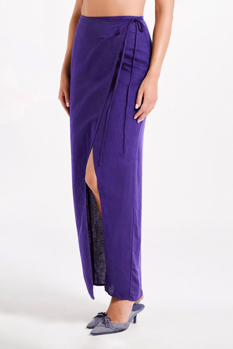 May include: A long purple wrap skirt with a side slit and a tie at the waist.