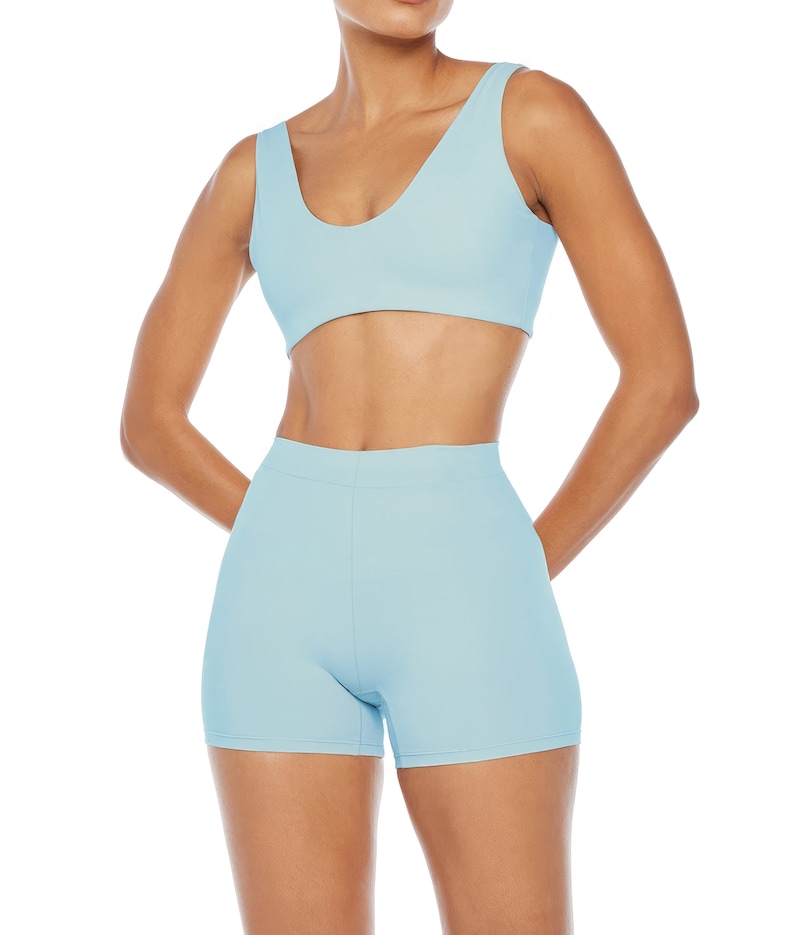 Pu&ograve; includere: Un completo sportivo a due pezzi azzurro. Il set comprende un reggiseno sportivo con scollo tondo e pantaloncini a vita alta. Il tessuto sembra essere un materiale liscio ed elastico. I pantaloncini sono lunghi circa 20 cm.