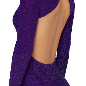 May include: A long-sleeved, form-fitting dress in a shimmering purple fabric. The dress features a keyhole back design, showcasing a glimpse of the back. The fabric has a subtle sparkle, adding a touch of glamour to the garment.