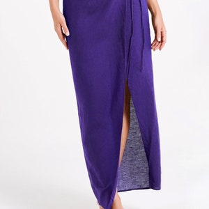 May include: A long purple wrap skirt with a side slit and a tie closure at the waist.