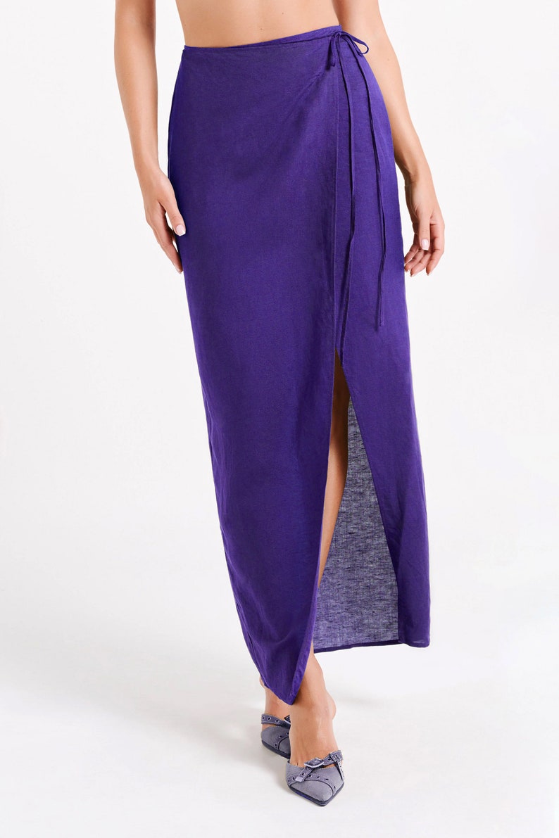 May include: A long purple wrap skirt with a side slit and a tie closure at the waist.