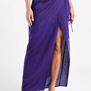 May include: A long, purple wrap skirt with a thigh-high slit and a tie closure at the waist.
