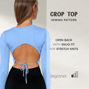 May include: A light blue crop top with long sleeves and an open back design, tied with a string. The text on the right says "Crop Top Sewing Pattern" and "Open Back with Snug Fit for Stretch Knits".