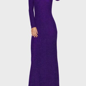 May include: A long, shimmering purple dress with long sleeves. The dress has a fitted silhouette that flows to the floor. The fabric has a subtle sparkle, catching the light. The dress has a high neckline.