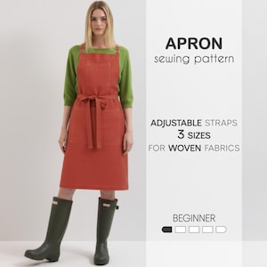 May include: A rust-colored apron with adjustable straps and a waist tie is shown. The apron has two front pockets and is worn over a green long-sleeve shirt. Text on the image reads "APRON sewing pattern" and "3 sizes for woven fabrics."
