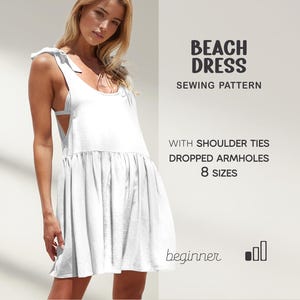 May include: White beach dress with shoulder ties and dropped armholes. The text on the image says "Beach Dress Sewing Pattern" and "8 Sizes". The dress has a loose, flowing design, perfect for a summer day.