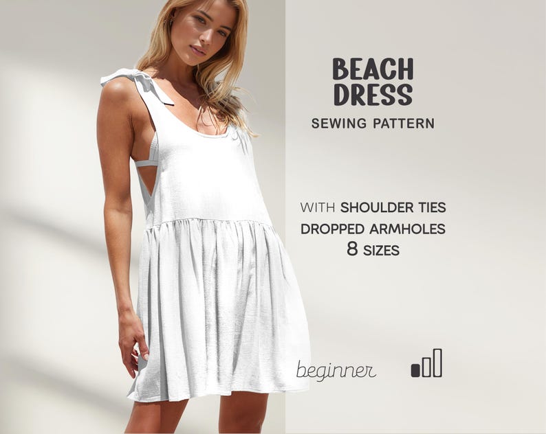 May include: White beach dress with shoulder ties and dropped armholes. The text on the image says "Beach Dress Sewing Pattern" and "8 Sizes". The dress has a loose, flowing design, perfect for a summer day.