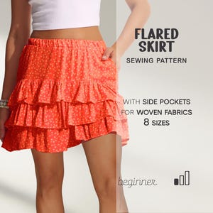 May include: A vibrant orange flared skirt with a tiered, ruffled design and a small floral pattern. The skirt has side pockets and is for woven fabrics. The image text reads "Flared Skirt Sewing Pattern" and "8 Sizes".