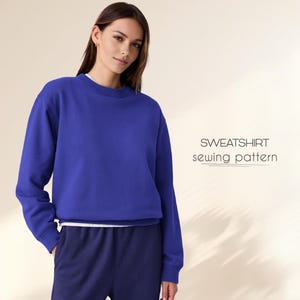 May include: A blue sweatshirt sewing pattern. The pattern is shown on a model wearing the sweatshirt.