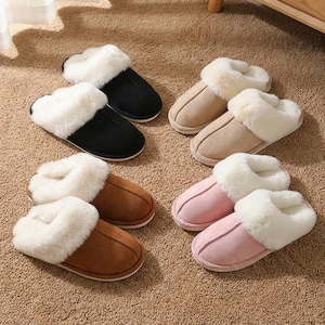 Peut inclure: Plusieurs pantoufles &agrave; bout ouvert de couleurs vari&eacute;es : noir, beige, marron et rose. Chaque pantoufle est doubl&eacute;e et bord&eacute;e de fausse fourrure blanche et douce. Les pantoufles sont dispos&eacute;es sur un tapis de couleur neutre.