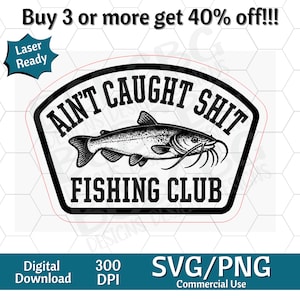 May include: A black and white graphic design featuring a catfish illustration centered within a badge shape. The text reads AIN'T CAUGHT SHIT FISHING CLUB in bold black lettering. The design includes a thin red outline and is labeled as Laser Ready.