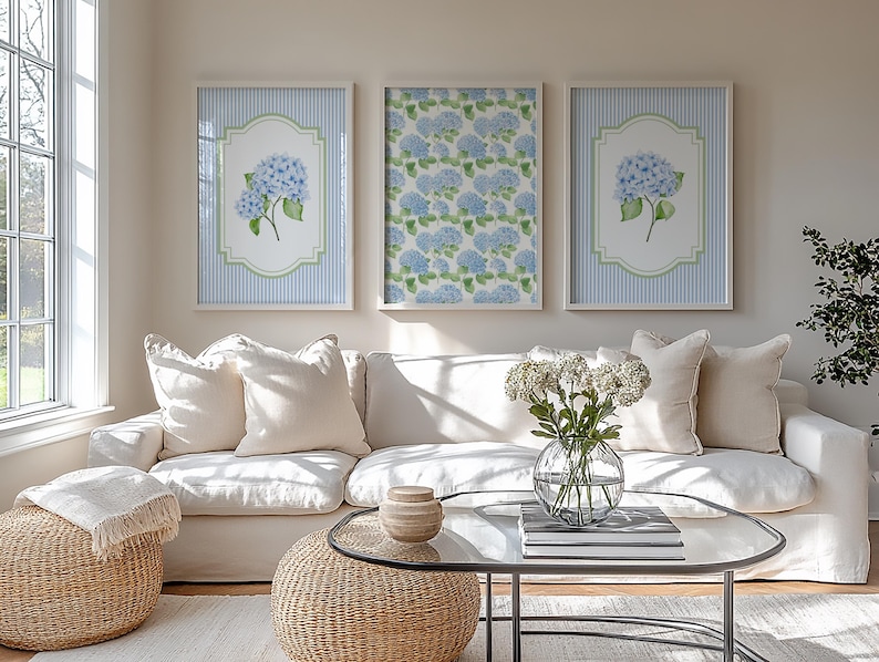 May include: Three framed wall art pieces with blue hydrangea floral prints. Two prints have a blue and white striped background with a floral design in a white and green frame. The third print has a blue floral pattern.
