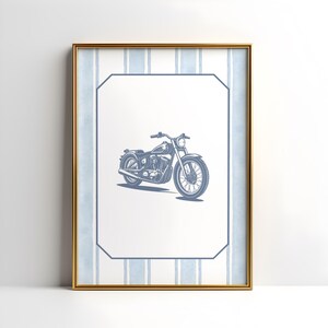 May include: Framed print featuring a blue motorcycle illustration. The artwork is set against a white background with a blue striped border and a gold frame. The motorcycle is detailed with visible engine and wheel spokes.