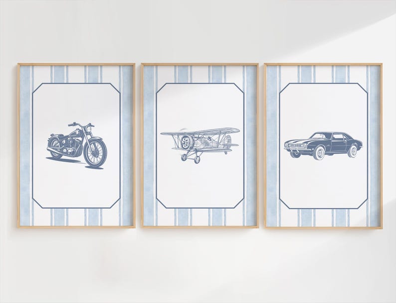 May include: Three framed prints featuring vintage vehicles. The prints showcase a motorcycle, a biplane, and a classic car, all in a blue and white color scheme. Each print is set against a striped background and framed in light wood.