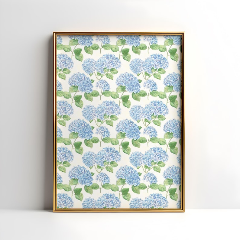May include: A framed print with a repeating pattern of blue hydrangea flowers and green leaves on a cream background. The gold-coloured frame is rectangular, suitable for wall decor.