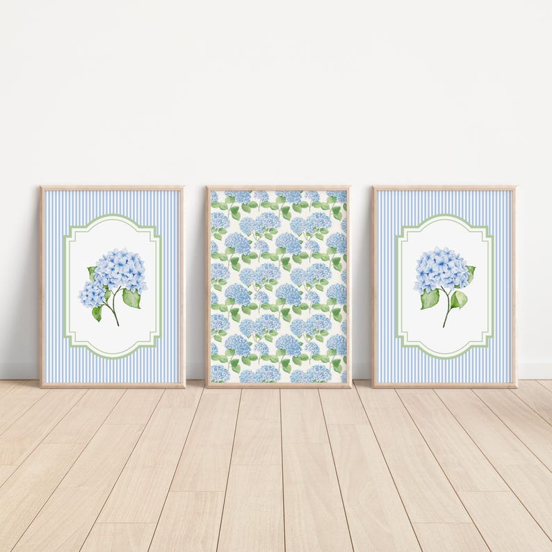 May include: Three framed art prints featuring blue hydrangea flowers. Two prints have a blue and white striped background with a floral design in a white and green frame. The third print has a repeating hydrangea pattern.