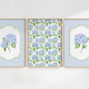 May include: Three framed art prints showcasing blue hydrangea flowers. Two prints have a blue and white striped background with a white and green framed hydrangea. The central print displays a pattern of blue hydrangeas on a white backdrop.
