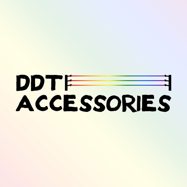 The DDT Accessories Logo which is the text DDT Accessories next to a set of wrestling ring ropes and turnbuckles with the ropes pride flag coloured