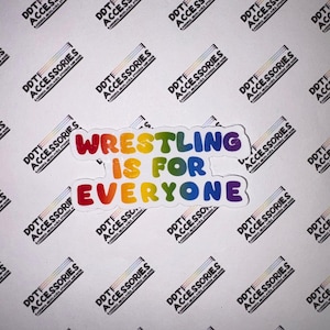 Puede incluir: Una pegatina blanca con el texto "Wrestling is for Everyone" en colores arcoíris. La pegatina tiene un borde negro. El fondo está cubierto con logotipos de "DDT Accessories".