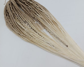 May include: A bundle of ombre synthetic hair extensions in shades of light brown and white. The hair is long and straight, with a slight wave at the ends.