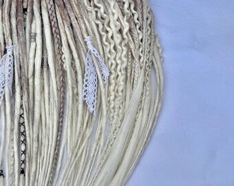 May include: A set of white and light brown synthetic dreadlocks with white lace accents. The dreadlocks are arranged in a fan shape and are tied together with a ribbon.
