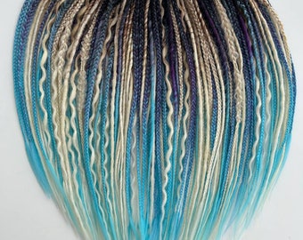 May include: A set of synthetic dreadlocks in various shades of blue, white, and black. The dreadlocks are arranged in a heart shape and have a ombre effect, transitioning from dark to light.