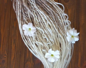 May include: A set of long, synthetic dreadlocks in shades of brown and white, with white flowers attached. The dreadlocks are arranged in a loose braid and are hanging down.