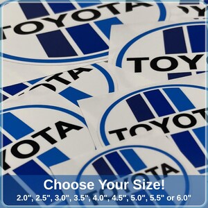 May include: A collection of white and blue Toyota logo stickers. The stickers display the Toyota logo in a blue and white design. The text at the bottom reads "Choose Your Size!" with size options from 5.08 cm to 15.24 cm.