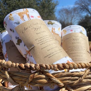 May include: A white ceramic mug with a black handle and the text "But First, Coffee" in a bold, black font. The mug is set against a blurred background, highlighting its clean design.