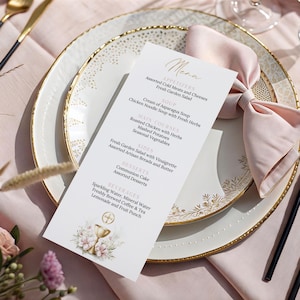 Può includere: Un menu cartaceo bianco con testo in corsivo dorato intitolato Menu, che elenca antipasti, zuppe, portate principali, contorni, dessert e bevande. La carta presenta un'illustrazione di un calice dorato con fiori rosa su un piatto con bordo oro.