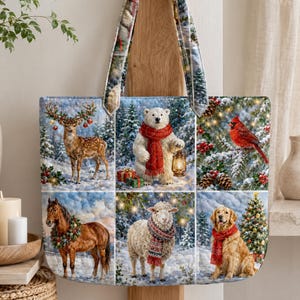 Puede incluir: Un bolso tote acolchado con un estampado de seis escenas invernales. Los paneles muestran un ciervo, un oso polar con una linterna, un cardenal, un caballo con una corona, una oveja con bufanda y un golden retriever con bufanda roja.