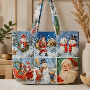 Op de afbeelding: Een gewatteerde tas met een kerstprint in meerdere panelen. Het ontwerp bevat illustraties van de Kerstman, sneeuwpoppen, een rode slee vol cadeaus en kinderen in een besneeuwd landschap, voorzien van twee bijpassende stoffen schouderbanden.