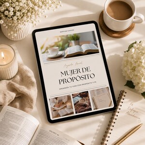 May include: A digital tablet displays the text "MUJER DE PROPÓSITO" with additional text and images. The tablet is surrounded by a cup of coffee, a lit candle, a notebook, and open books. The scene is set on a white surface with floral arrangements.