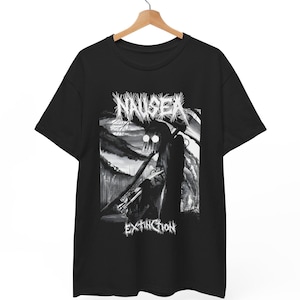 Peut inclure: T-shirt noir avec un motif en niveaux de gris. Le design présente le mot "NAUSEA" au-dessus d'une figure et le mot "EXTINCTION" en dessous. L'œuvre a un style sombre et artistique avec une esthétique grunge. Le t-shirt est suspendu à un cintre en bois.