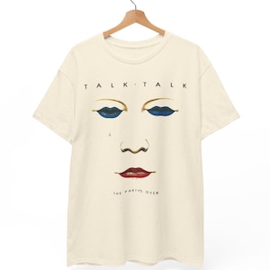 May include: Cream-colored t-shirt featuring a stylized face design with blue eyeshadow, a teardrop, and red lips. The text "TALK TALK" is above the face, and "THE PARTY'S OVER" is below.