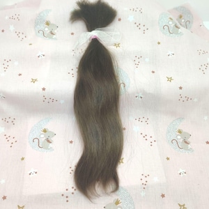 May include: A bundle of straight, medium-brown human hair tied at the top with a sheer white ribbon. The hair is smooth and uniform in texture, featuring a natural dark brown color throughout the length of the strands, secured by a small pink band.